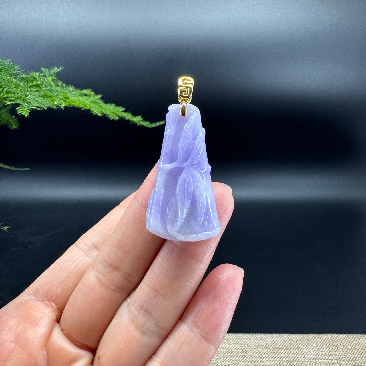 The shape of the pendant is that of a bamboo. Lavender jadeite bamboo with yellow gold bail.
