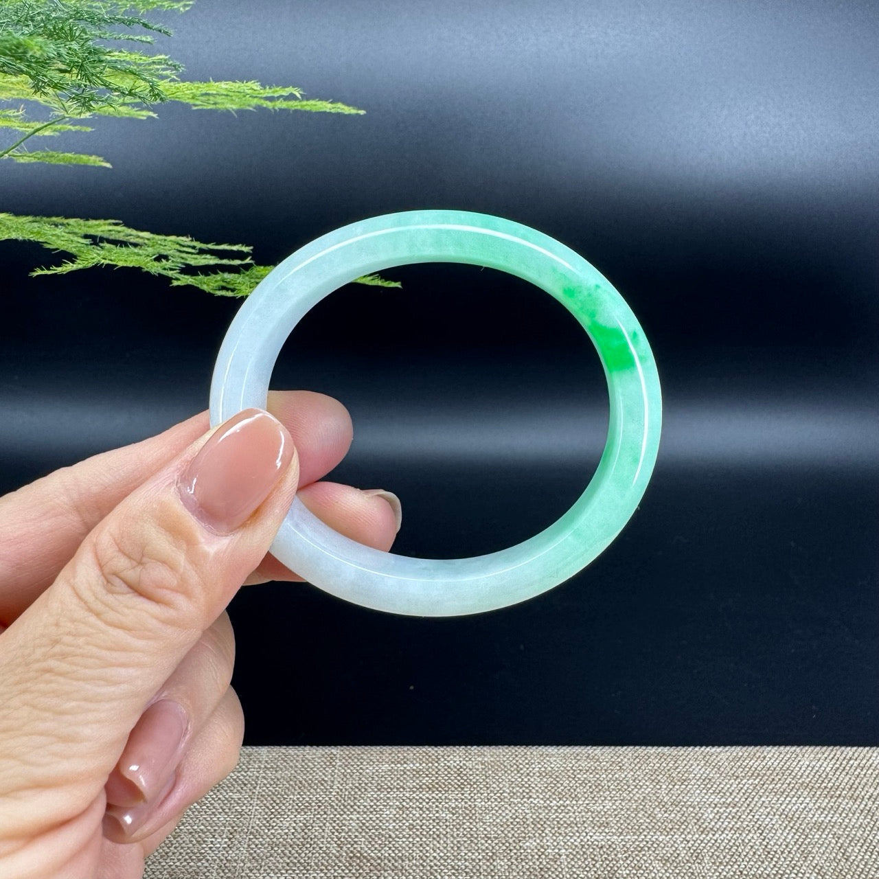 The bangle shape of the oval half round.The bangle color is white green.