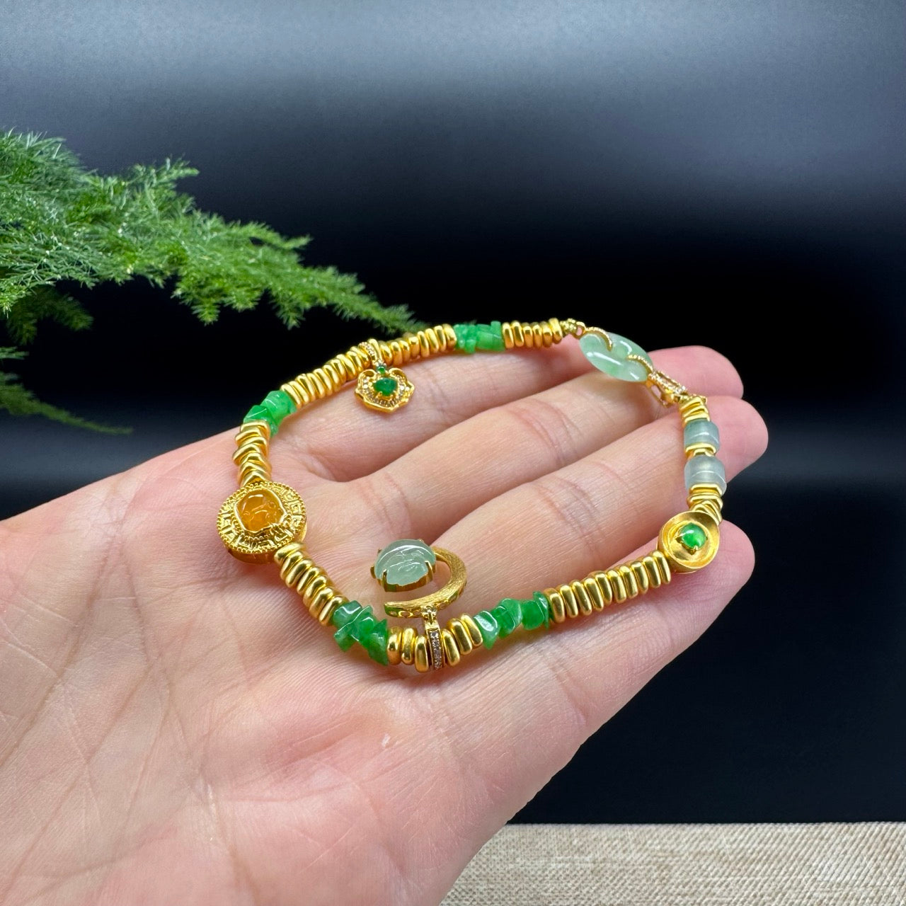 The bracelet design a green mini ruyi, yellow pixiu, yellow gold moon with an ice green rabbit, and ice green koukou with gold clasp, decorated with some diamonds. 