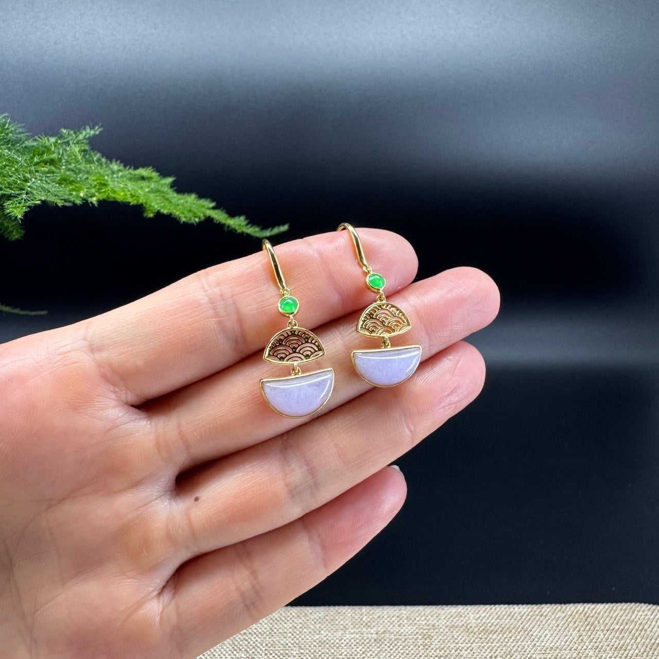 The shape of the dangle earrings is that of a fan-shaped of moon. The jade is lavender color, and it is surrounded by 18k yellow gold.