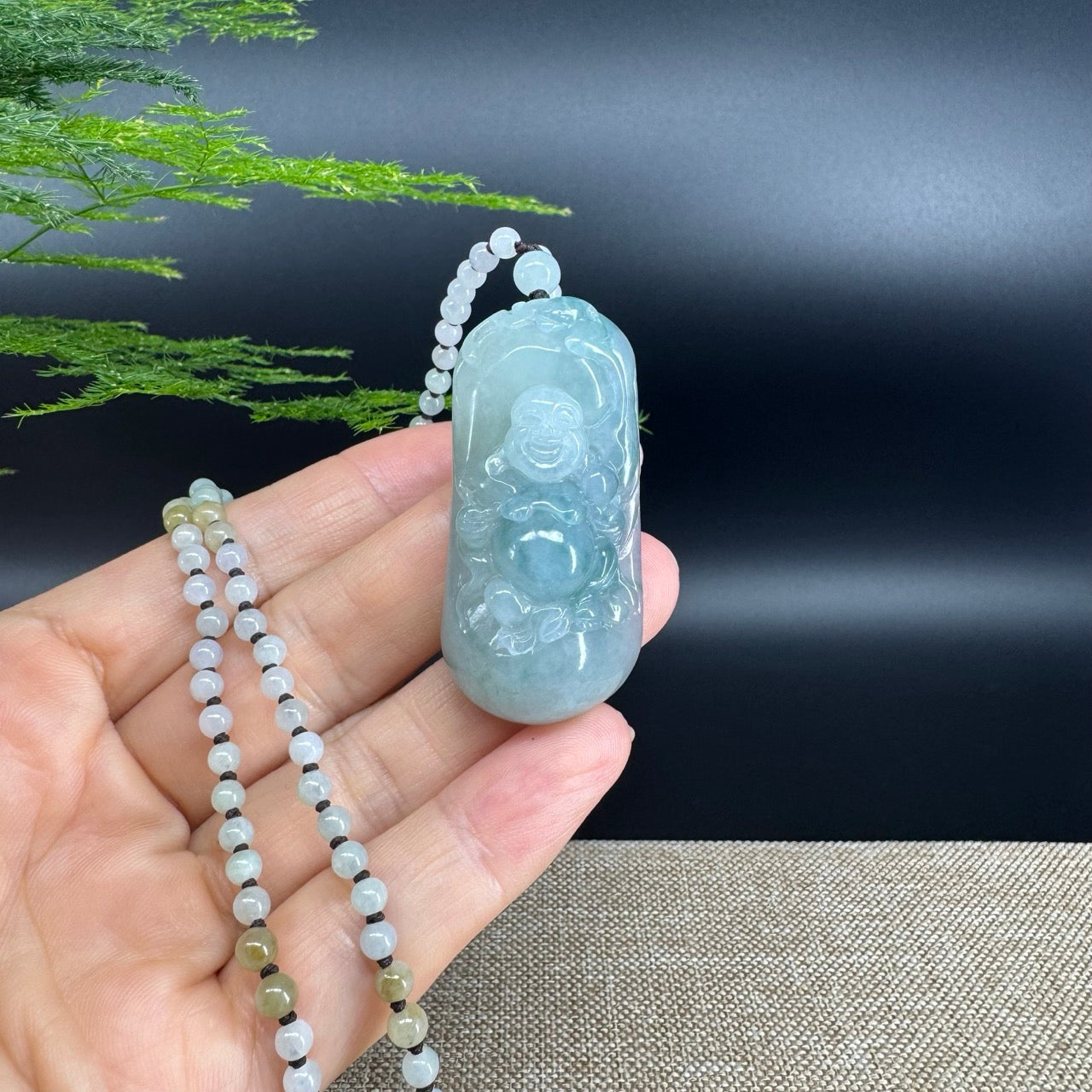 The pendant shape of the buddha.The pendant color is blue green.