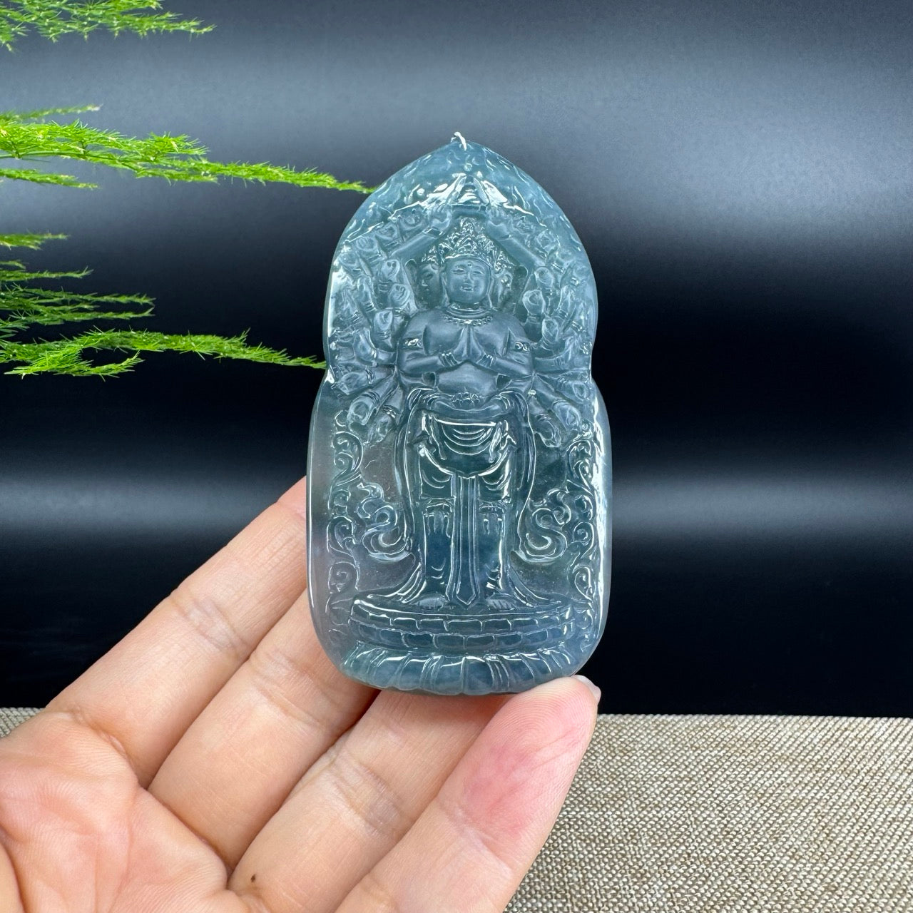 The pendant shape of the thousand hand guanyin.The pendant color is blue .